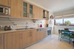 a kitchen with wooden cabinets and a table in it at Casa Teresa in Vilamoura
