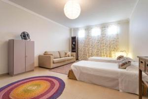 a bedroom with a large bed and a couch at Casa Teresa in Vilamoura +11 photos