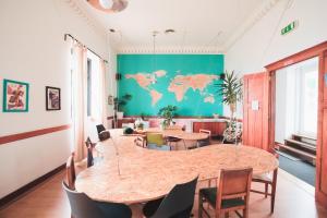 a room with a table and a world map on the wall at Sunset Destination Hostel in Lisbon