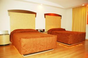 ein Hotelzimmer mit 2 Betten in einem Zimmer in der Unterkunft Panorama Hotel  in Mexiko-Stadt