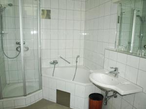 ウィーンにあるホテル テルミナスのバスルーム(バスタブ、シンク、シャワー付)