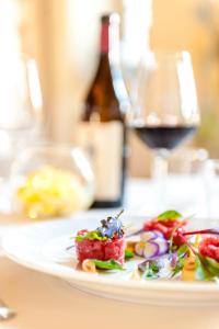 a plate of food on a table with a bottle of wine at Hotel Il Campanile in Cherasco