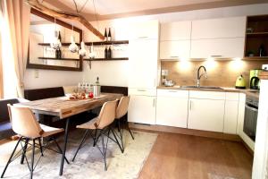 a kitchen with a wooden table and white cabinets at CHALET BELLE KITZ by Belle Stay in Kitzbühel