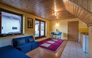 ein Wohnzimmer mit einem blauen Sofa und einer Küche in der Unterkunft Chalupa LUKA Terchová in Terchová