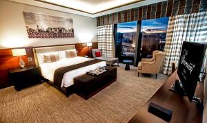 a hotel room with a large bed and a living room at Apartments by Fairmont Baku Flame Towers in Baku