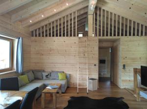 リーツラーンにあるWalser Berg Chaletsのソファ付きのリビングルーム、木製の壁