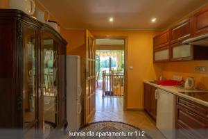 a kitchen with a refrigerator and a door to a patio at Willa Gwiazda in Szklarska Poręba