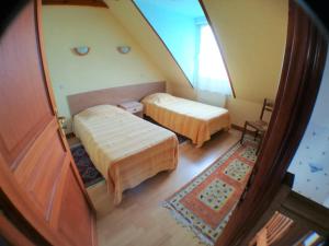 an attic room with two beds and a window at Chez JoMi in Trébeurden