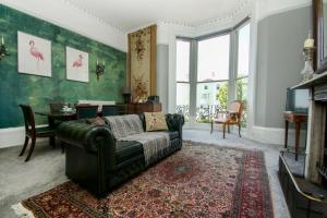 ein Wohnzimmer mit einem Sofa und einem Tisch in der Unterkunft Regency Apartment - Sea View - by Brighton Holiday Lets in Brighton & Hove