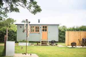a tiny house in a yard with a fence at Morndyke Shepherds Huts in Thirsk