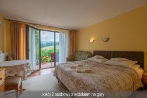 a bedroom with a large bed and a large window at Willa Gwiazda in Szklarska Poręba