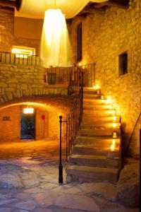 a staircase in a stone building with lights at Comptoir Saint-Hilaire in Saint-Hilaire-de-Brethmas