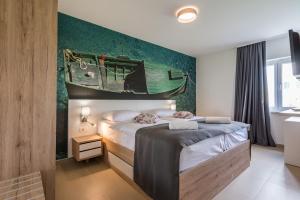 a bedroom with a bed with a boat on the wall at Apartments Vila 4m in Ražanac