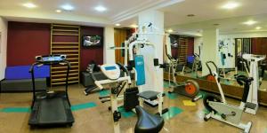 a gym with treadmills and machines in a room at Sarmiento Palace Hotel in Buenos Aires