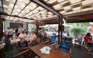 a group of people sitting at tables in a restaurant at Attila Beach Boglár in Balatonboglár