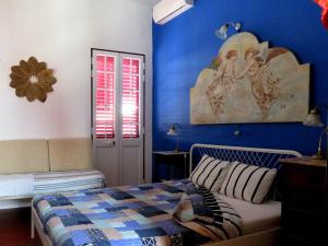1 dormitorio con cama y pared azul en Pátio das Andorinhas en Ferreira do Alentejo