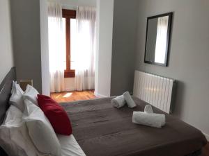 - une chambre dotée d'un grand lit avec des oreillers rouges et blancs dans l'établissement AZ El Balcón de Rey Alfonso II, à Saragosse