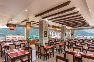a dining room with tables and chairs and windows at Bodhi Suites Boutique Hotel and Spa in Pokhara