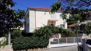 a white house with a fence in front of it at Apartment Ivo in Trogir