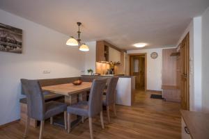 una cucina e una sala da pranzo con tavolo e sedie in legno di Appartement Reischerhof a Going