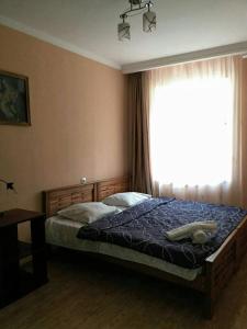 a bedroom with a bed with a large window at Guest House Liana in Tbilisi City