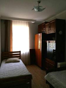 a bedroom with a bed and a refrigerator and a window at Guest House Liana in Tbilisi City