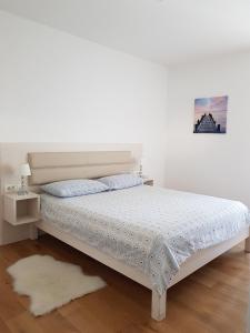 een slaapkamer met een bed met een witte sprei bij Apartment Domalu Old Town in Zadar