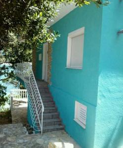 een blauw gebouw met een trap die naar een deur leidt bij Apartman Volarevic in Donji Karin