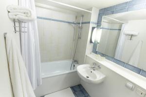 a bathroom with a sink, toilet and bathtub at Campanile Hotel & Restaurant Brussels Vilvoorde in Vilvoorde