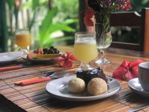 a table with a plate of food and a glass of orange juice at Pousada Corais Do Sul in Caraíva