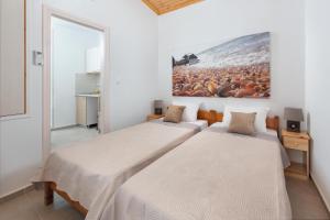 2 Betten in einem Zimmer mit Wandgemälde in der Unterkunft Elena in Symi