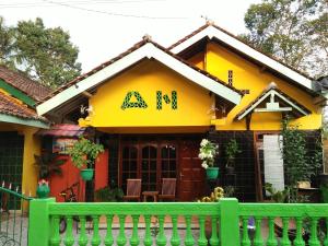 a yellow house with an am sign on it at Penginapan Ana Indah in Borobudur