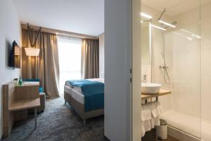 una camera da letto con un letto e un bagno con un lavandino di Das Alfred a Sankt Pölten