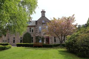 an old stone house with a bench in the yard at Carnach House in Nairn