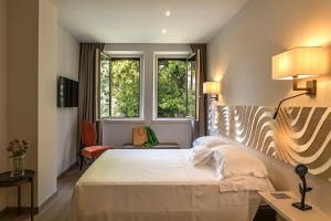 una camera con un grande letto e due finestre di Hotel Laurin a Salò