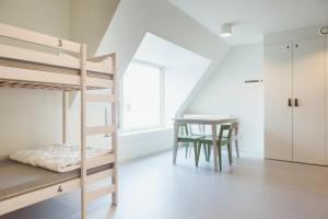 a bedroom with bunk beds and a table and a desk at Snuffel Youth Hostel in Bruges +61 photos