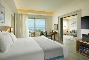 a hotel room with a bed and a view of the ocean at St Raphael Resort in Limassol
