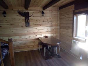 ベロクリハにあるGuest House Kovchegの木製の壁のテーブル付きの部屋