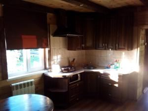 ベロクリハにあるGuest House Kovchegのキッチン(木製キャビネット、コンロ、テーブル付)