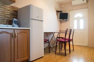 a kitchen with a refrigerator and a table with chairs at Villa Palma Ceoce in Budva
