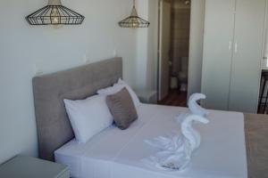 a white bed with two swans on it at River View Boutique Apts in Ayia Napa