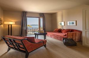 a living room with a red couch and a window at Hotel Laurin in Salò