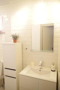 a white bathroom with a sink and a mirror at Casinha 28 in Faro