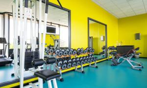 a gym with yellow walls and lots of equipment at Thon Hotel Arena in Lillestrøm