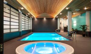 een groot zwembad in een gebouw met een hot tub bij Thon Hotel Arena in Lillestrøm