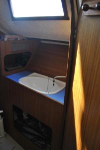 ein kleines Zimmer mit einem Waschbecken in der Mitte in der Unterkunft nuit sur un voilier in Nonsard