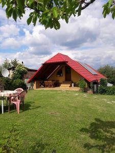 una casa con techo rojo y una mesa en un patio en apartman-bartko en Banská Štiavnica