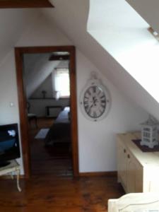 a room with a clock on the wall and a staircase at apartman-bartko in Banská Štiavnica +14 photos