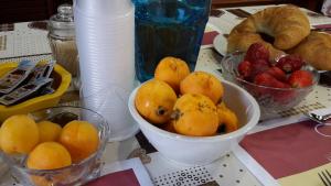 a table with bowls of fruit and plates of bread at Villa Salvatore in San Leone