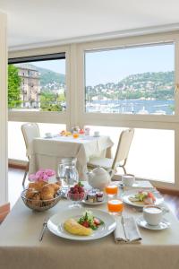 una mesa de desayuno con comida y vistas al océano en Hotel Barchetta Excelsior, en Como